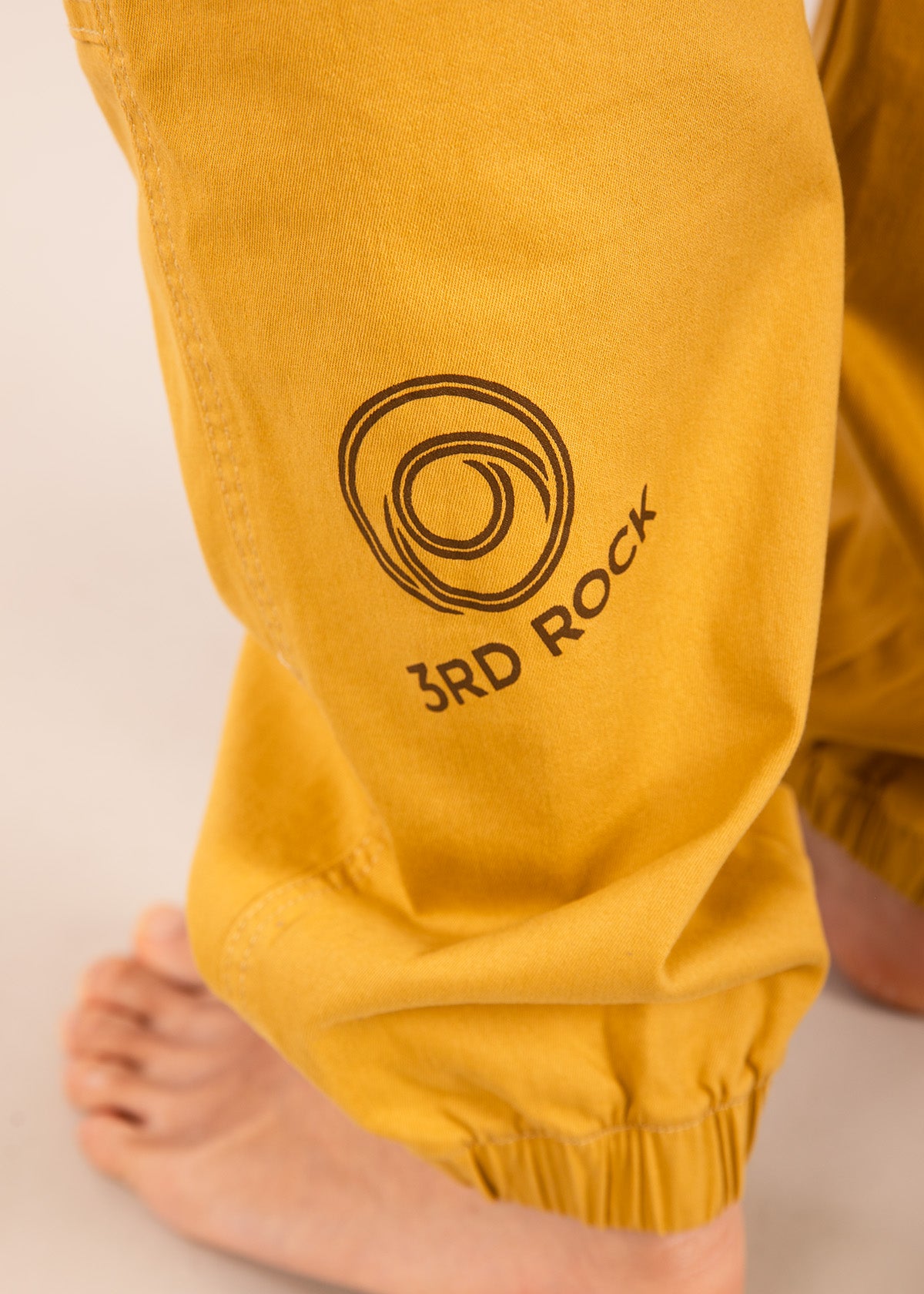 A close up photo showing our printed calf logo on the honey badger yellow nova trousers